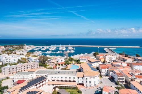 an aerial view of a city with a harbor at Cala Della Torre Resort in La Caletta