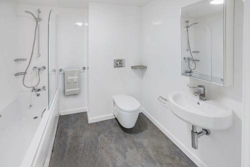 a white bathroom with a toilet and a sink at Chapter Ealing in North Acton in London