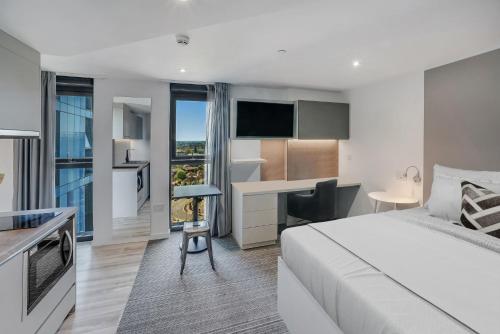 a hotel room with a bed and a desk and a kitchen at Chapter Ealing in North Acton in London