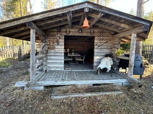 a wooden cabin with a table and a dining room at Pihasauna Mökki - Villa Alpaca Laamatila in Nokia