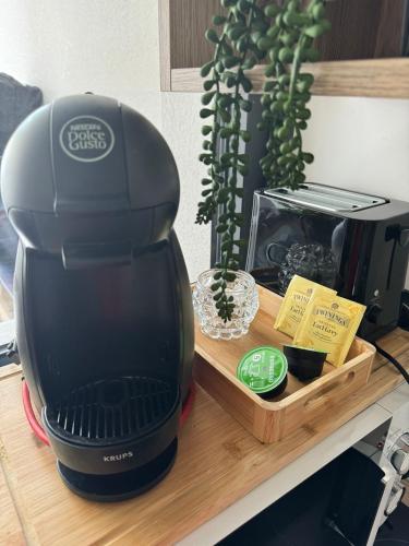 une cafetière noire sur un comptoir avec une boîte dans l'établissement studio Lauralex, à Montardon