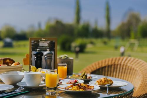 a table topped with plates of food and orange juice at Gutshof Sagmühle in Bad Griesbach