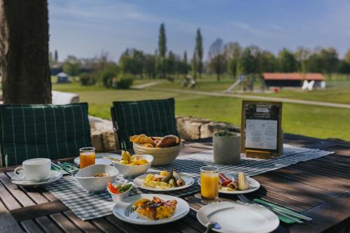 a wooden table with plates of food on a picnic table at Gutshof Sagmühle in Bad Griesbach