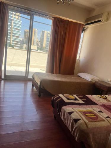 una camera d'albergo con due letti e una grande finestra di Rawche 30 Apartments a Beirut
