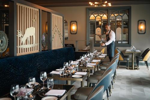 a man standing in front of a dining room at Hotel67 at Gleneagle in Killarney