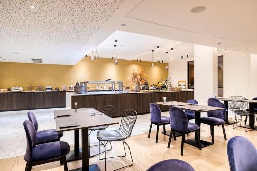 un restaurant avec des tables, des chaises et un comptoir dans l'établissement Corsendonk Turnova, à Turnhout