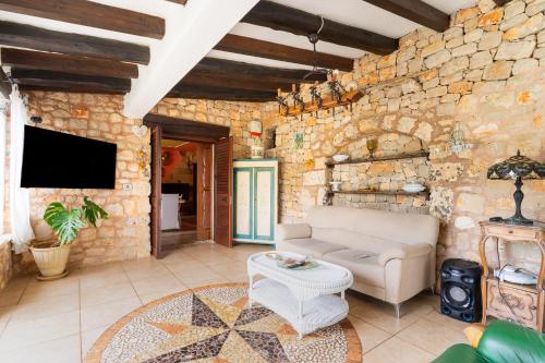 a living room with a couch and a tv at Villa Tiziana in Castrignano del Capo