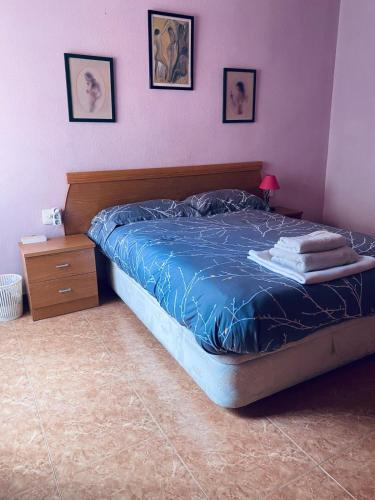 a bedroom with a bed with a blue comforter at Completa y Amplia Habitación a 10 minutos de la playa Casa Compartida in Algaida