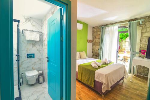 - une chambre avec un lit et une salle de bains avec des toilettes dans l'établissement Bedirhan Konak Otel, à Alaçatı