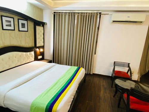 a hotel room with a bed and a desk and a bed at Hotel Fabstays-Safdarjung Enclave in New Delhi