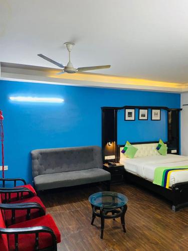 una camera con letto, divano e tavolo di Hotel Fabstays-Safdarjung Enclave a Nuova Delhi