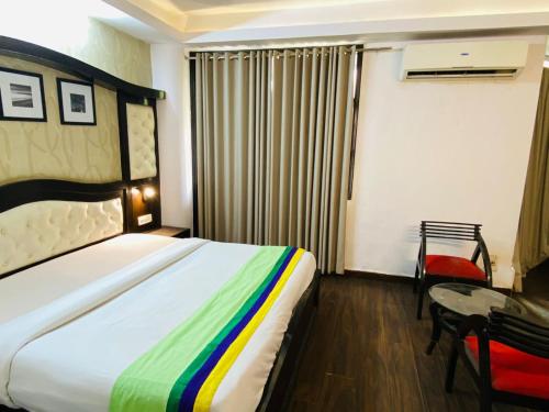 una camera con letto, sedia e tavolo di Hotel Fabstays-Safdarjung Enclave a Nuova Delhi