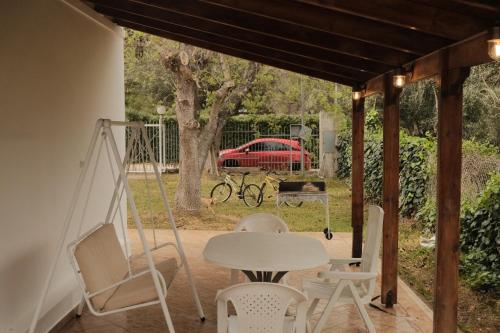 a porch with a table and chairs and a swing at Close to Airport 5 Bedroom Villa by the Sea in Nea Makri