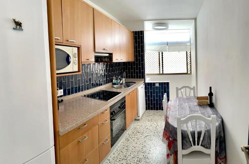 a kitchen with wooden cabinets and a table with a tableablish at AGUA MARINA in Candelaria