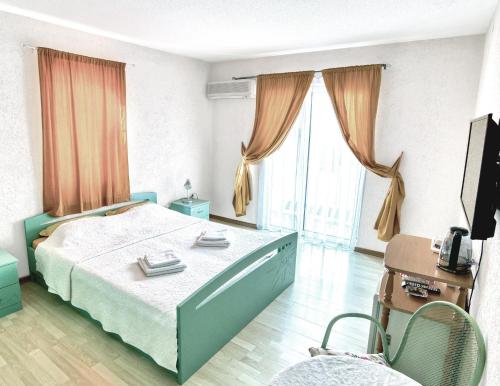 1 dormitorio con 1 cama y TV en Sun Guest House, en Budva