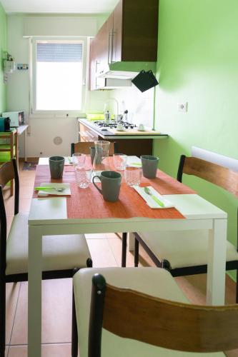 a kitchen with a wooden table with chairs and a dining room at SUN House in Chioggia