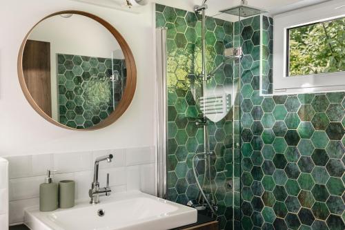 uma casa de banho com um lavatório e um chuveiro com um espelho. em Casa Quint em Csákberény