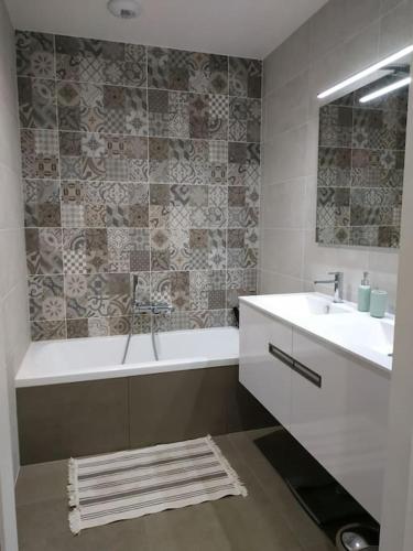 une salle de bain avec une baignoire et un lavabo et une baignoire dans l'établissement Maison architecte neuve - piscine - 400m océan, à Labenne