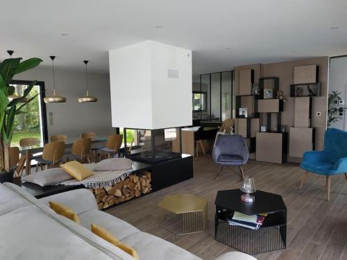 un salon avec un canapé et une salle à manger dans l'établissement Maison architecte neuve - piscine - 400m océan, à Labenne