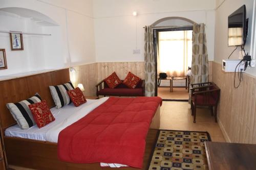 1 dormitorio con 1 cama grande con manta roja en Mi Casa Inn en Mussoorie