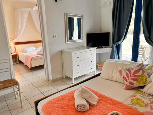 um quarto com uma cama, uma televisão e um espelho em Dreams Beach Apartments Katelios em Kateleios