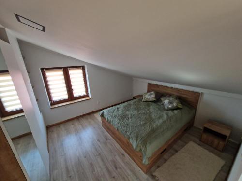 ein Schlafzimmer mit einem Bett und zwei Fenstern in der Unterkunft Apartament Gorzków 