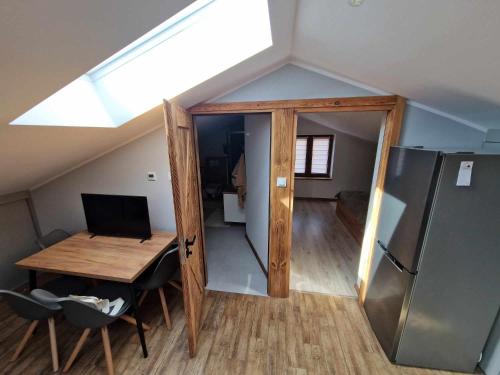 Zimmer im Dachgeschoss mit einem Schreibtisch und einem Kühlschrank in der Unterkunft Apartament Gorzków 