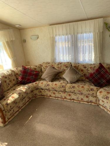 a couch with pillows sitting in a living room at Caravan 131 in Norwich