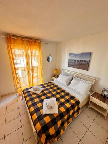 une chambre avec un grand lit avec une couverture à carreaux dans l'établissement Suite DES DOMES FSHH, à Nice