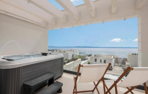 a balcony with a hot tub and two chairs at Villa Rosemary West in Makarska
