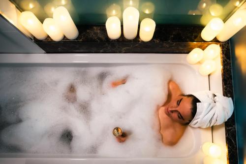 - un homme se reposant dans une baignoire à côté des bougies dans l'établissement Arctic City Hotel, à Rovaniemi