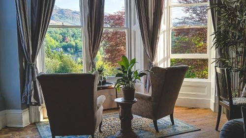 a living room with two chairs and a large window at Amazing Cader views Torrent en suite in Dolgellau