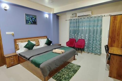 a bedroom with a bed and two red chairs at D2Stay Homestay 2Bhk for 5person Near Paltan Bazar in Guwahati