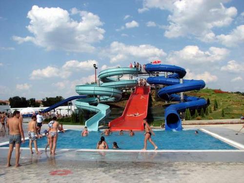 een groep mensen in een zwembad met een glijbaan bij Apartman Kućica u cveću in Jagodina