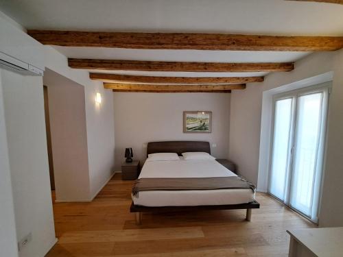 1 dormitorio con 1 cama en una habitación con techos de madera en Casa Rosada en Como