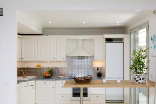 une cuisine avec des armoires blanches et un comptoir dans l'établissement Cristal Croisette YourHostHelper, à Cannes