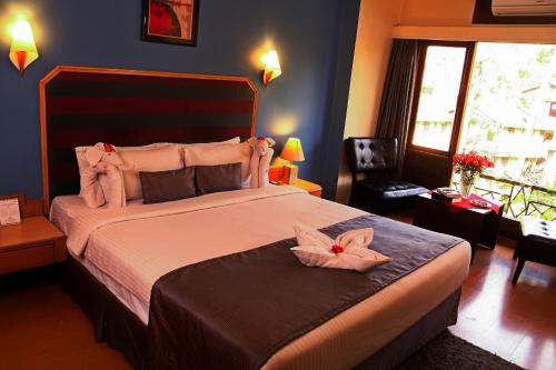 a bedroom with a large bed with two pink flowers on it at Hotel Polo Towers Shillong in Shillong