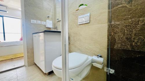 a bathroom with a toilet and a shower at BluO Stylish 2BHK New Town Rajarhat - Skyline View Condo in Thākurdwari