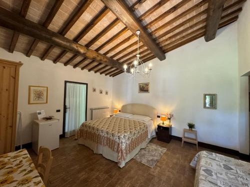 a bedroom with a bed in a room with wooden ceilings at B&B Il Fienile San Gimignano in San Gimignano