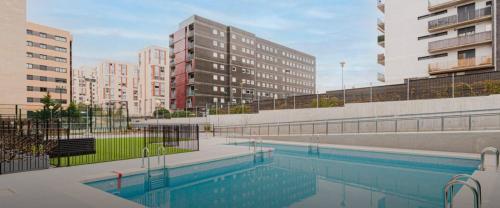 una piscina en una ciudad con edificios altos en Cómodo apartamento en Tres Cantos by beBalmy en Tres Cantos
