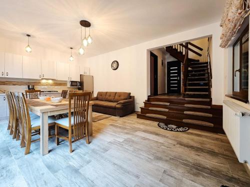 a kitchen and living room with a table and chairs at Căsuța din vis-Voroneț in Gura Humorului