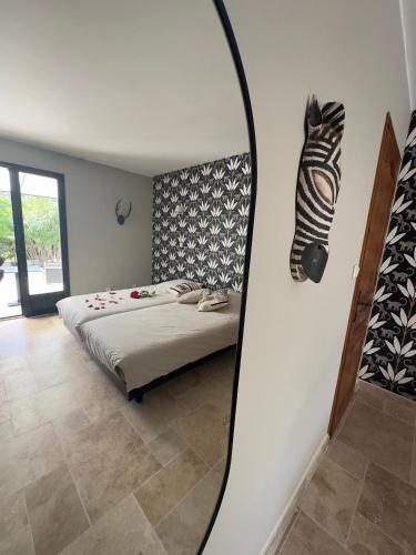 une chambre avec un lit et un miroir au mur dans l'établissement Les Iris Villa Piscine chauffée 6 pers, à Moissac-Bellevue