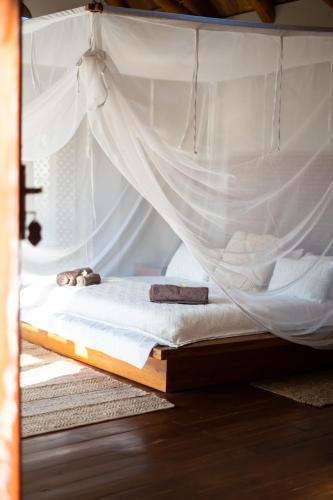 a bed with a mosquito net on top of it at Sia Sente Beach estate in Inhambane