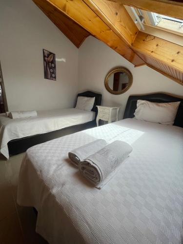 two beds with towels on them in a bedroom at Bedesten Pansiyon in Çeşme