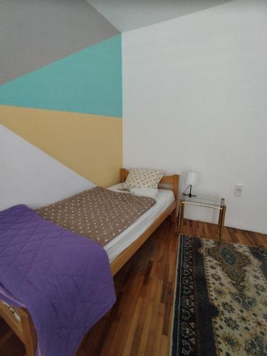 a bedroom with a bed and a colorful wall at Villa Ema rooms in Niš