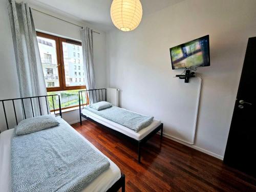 Zimmer mit 2 Betten und einem Flachbild-TV in der Unterkunft FIRST -- Green Żoliborz apartment 3 in Warschau