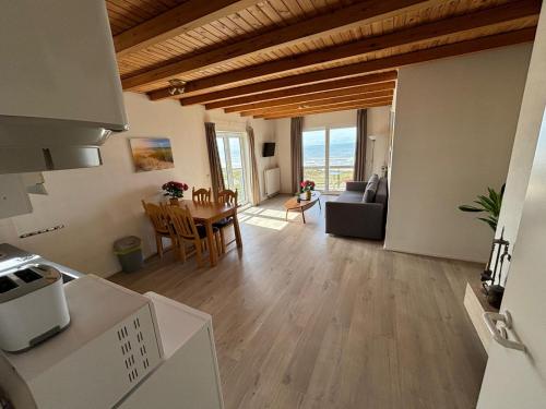 a kitchen and living room with a table and a couch at Villa aan Zee in Noordwijk