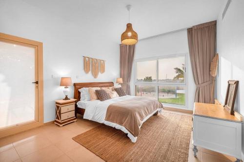 a bedroom with a bed and a large window at Marina Views Al Hamra Village in Ras al Khaimah