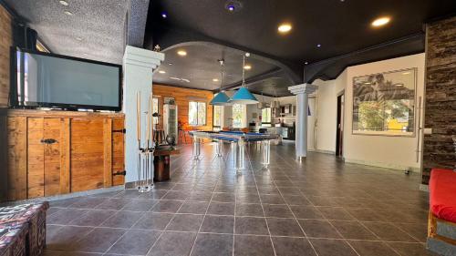 a living room with a tv and a pool table at The Modern & Recycled House in Machico