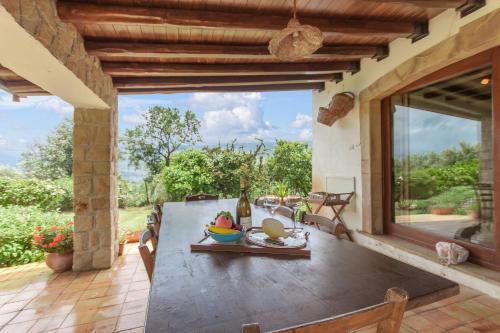 einen Tisch mit einer Obstschale auf einer Terrasse in der Unterkunft Villa Olmo With Private Pool in Castel di Lucio